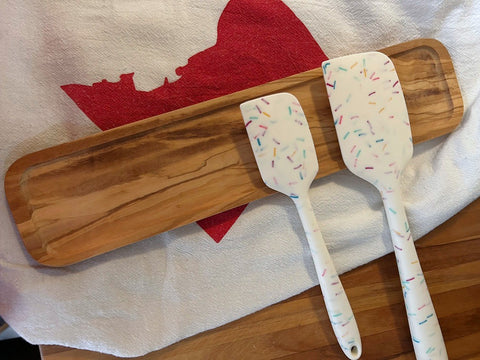 flat olivewood spoon rest with a short rim around the edge.